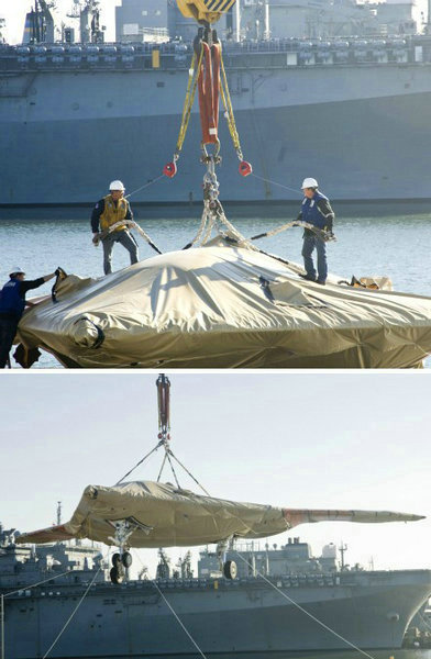 資料圖：美國海軍人員將一架X-47B無人空戰(zhàn)系統(tǒng)驗證機運送到杜魯門號航母上。