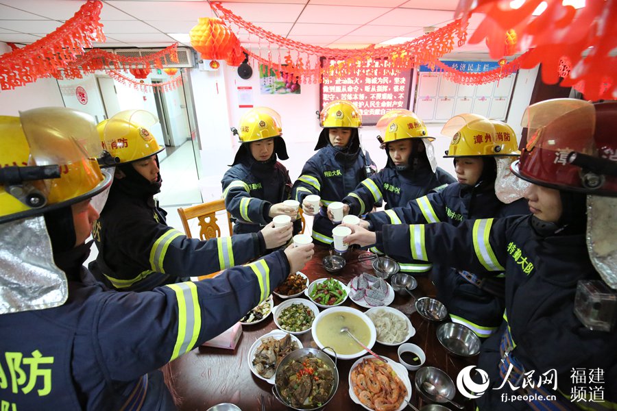 漳州消防特勤大隊一中隊消防指戰(zhàn)員歡聚一堂，吃年夜飯，舉杯共飲。
