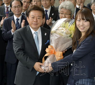 12月18日，高票當(dāng)選東京都新知事的豬瀨直樹正式到任。圖為豬瀨從政府職員手中接過(guò)花束。(共同社)