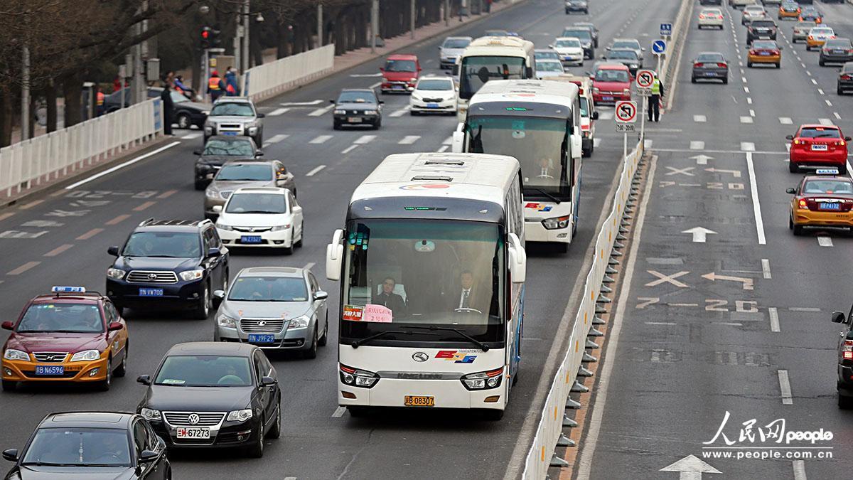 沒(méi)有封路及警車帶道，重慶代表團(tuán)接送車有序通過(guò)長(zhǎng)安街。吉羽/攝影