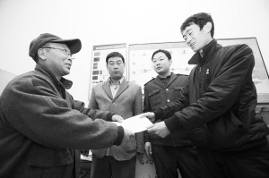 劉大爺莊重地將感謝信交到車隊隊長的手中。本報記者 李志華 攝