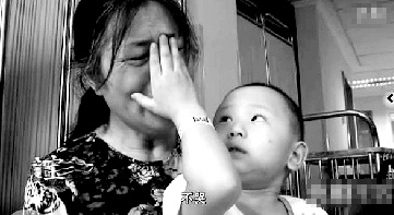 視頻中“小中寶”看到奶奶為他掉眼淚，就伸手為奶奶抹去眼淚。視頻截圖 