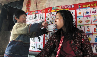 小孫悅為臥床的母親喂飯。