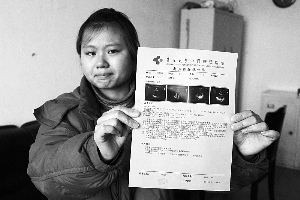 女孩眼含淚水向記者出示自己母親的診斷報告，希望好心人可以幫幫她的母親。　　攝影 李自強
