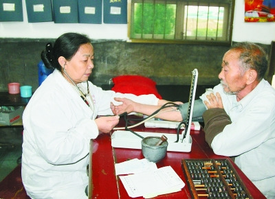 曾玉萍(左)在為患者看病。 喻無(wú)瑕 攝