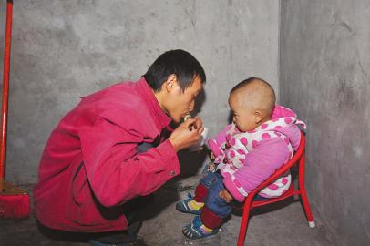 詹圓圓出門(mén)前給兒子喂飯。