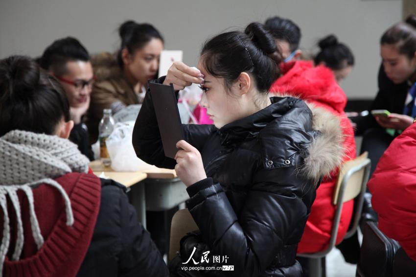2014年2月17日，山東濱州，藝考候考考生在濱州學(xué)院報名點化妝。