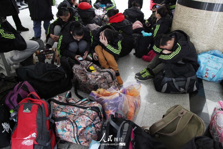 2014年2月17日，山東濱州，背著大包小包的藝考考生在濱州學(xué)院報名點候考。