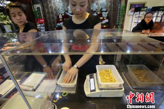 金店工作人員正在稱重。　張?jiān)啤z