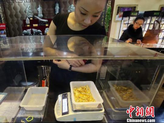 金店工作人員正在稱重。　張?jiān)啤z