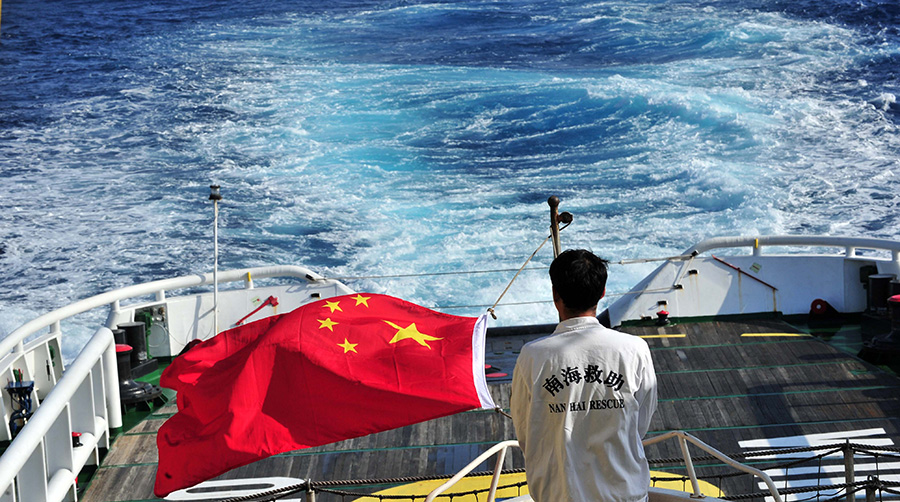 3月18日，水手李國棟在南海救101輪船甲板后部升起國旗。新華社記者 趙穎全攝