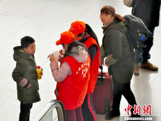 鐵路青年志愿者為攜帶兒童出行的旅客提供咨詢解答?！钦鳌z