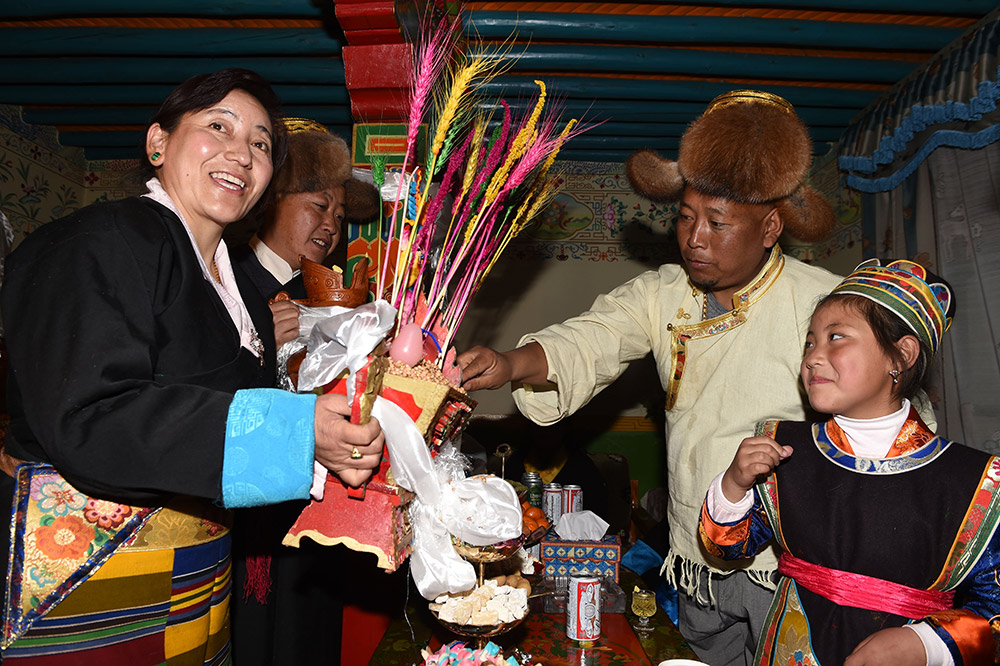 2月27日,拉薩市城關(guān)區(qū)阿壩林卡社區(qū)居民央拉(左)向鄰居敬獻“切瑪”。